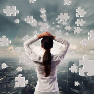 Woman looking at images of puzzle pieces implying the confusion of ADHD