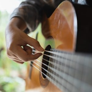 Photo of hand strumming guitar.